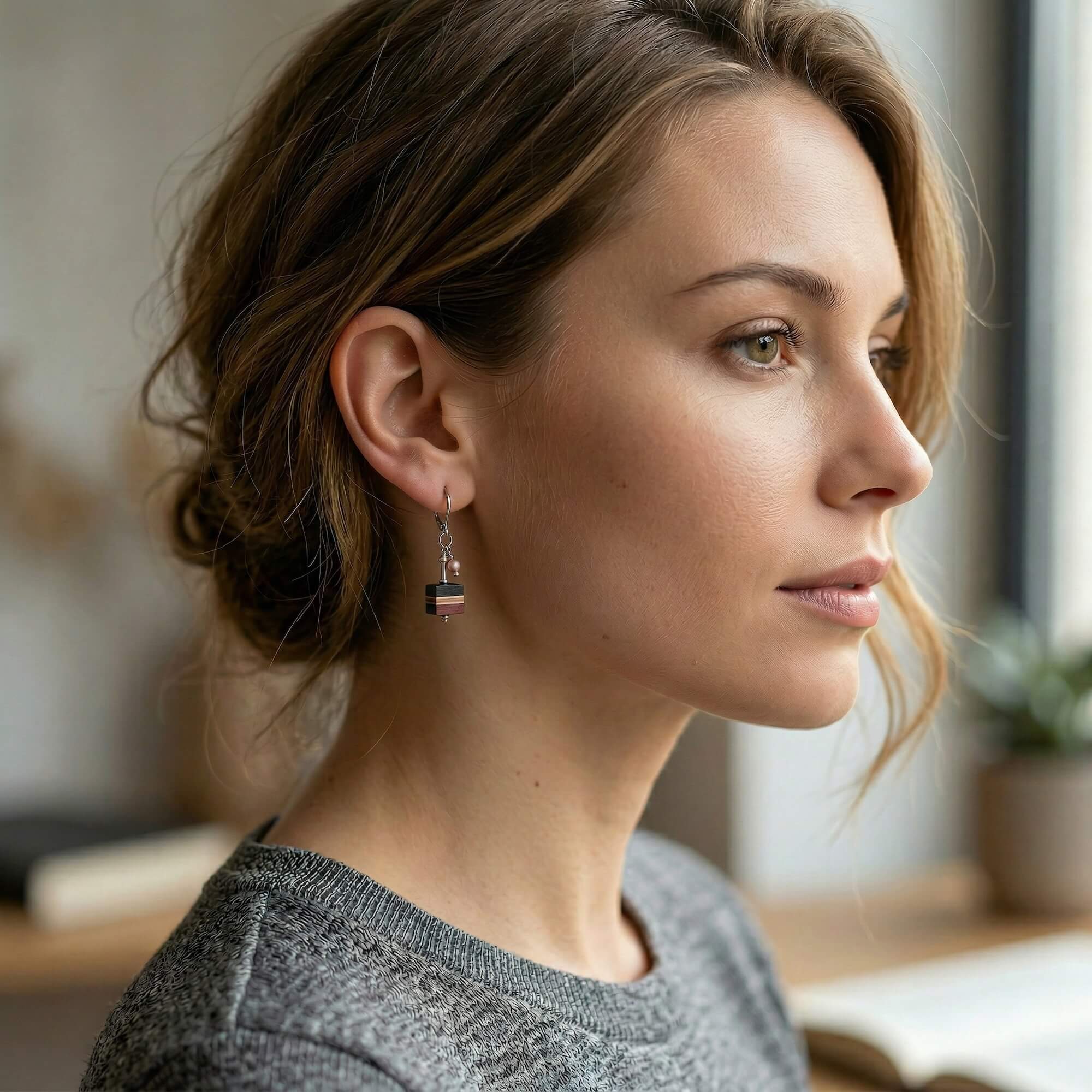 Femme portant des boucles d'oreilles pendantes avec perle et bois, bijou artisanal fait main au Québec